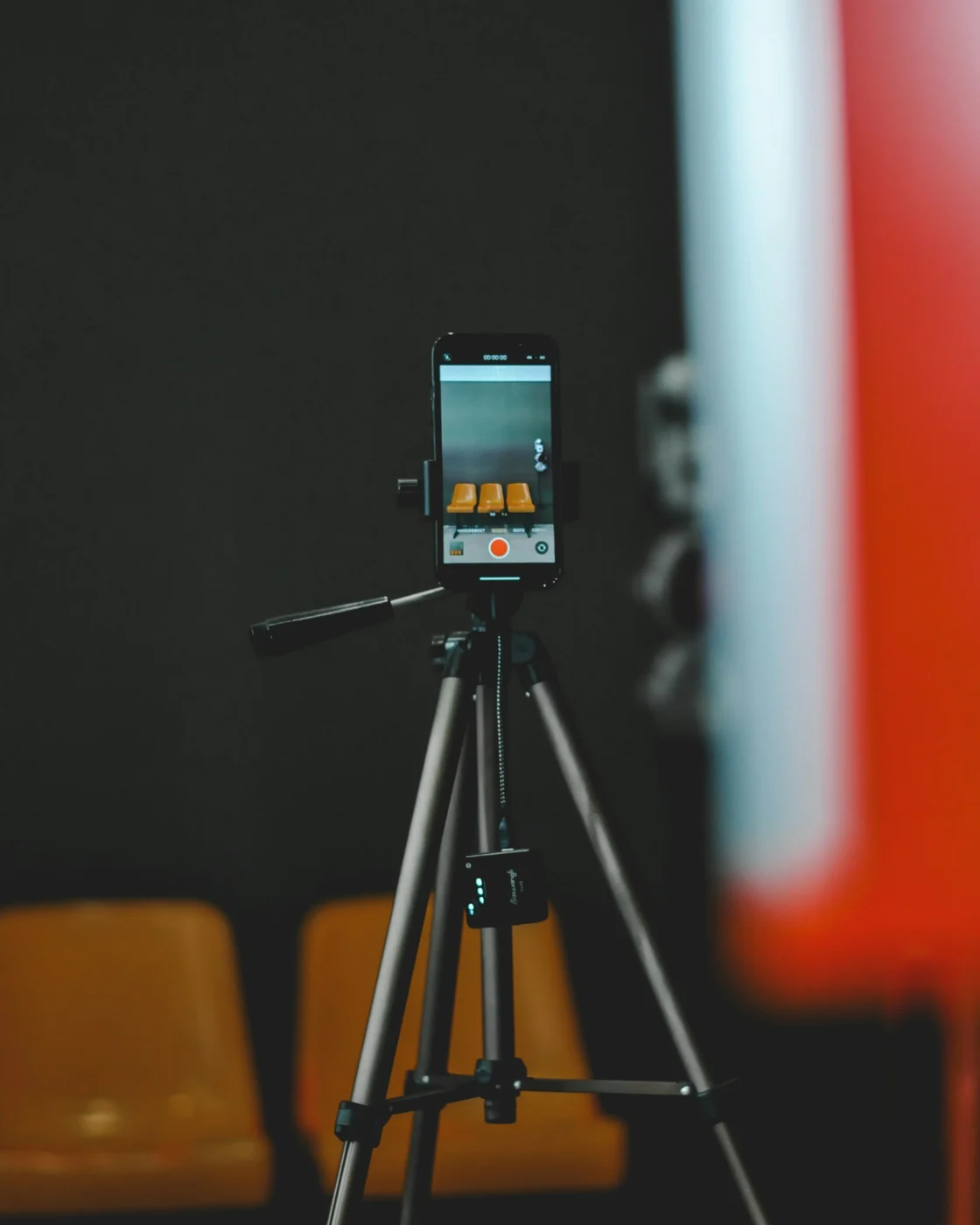 A smartphone on a tripod filming a scene in a studio