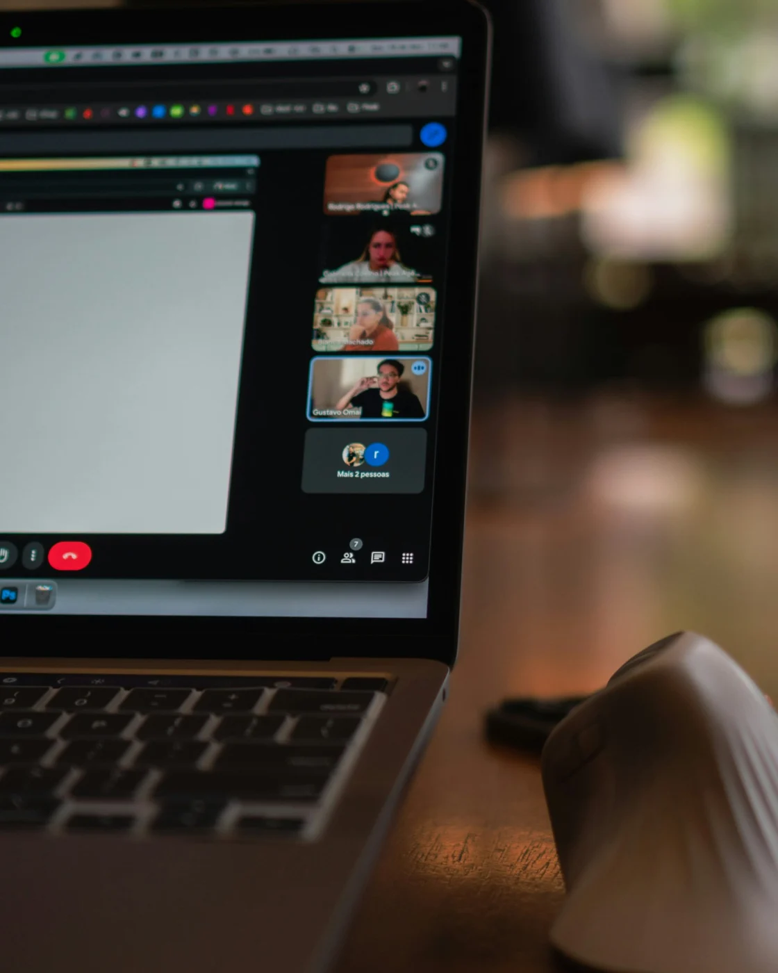 A laptop screen showing a video conference with several participants